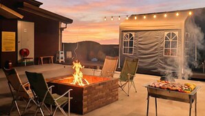 An outdoor patio with a fire pit, grilling area, and camping-style tent. - Yunseulga Bada (Seoul)