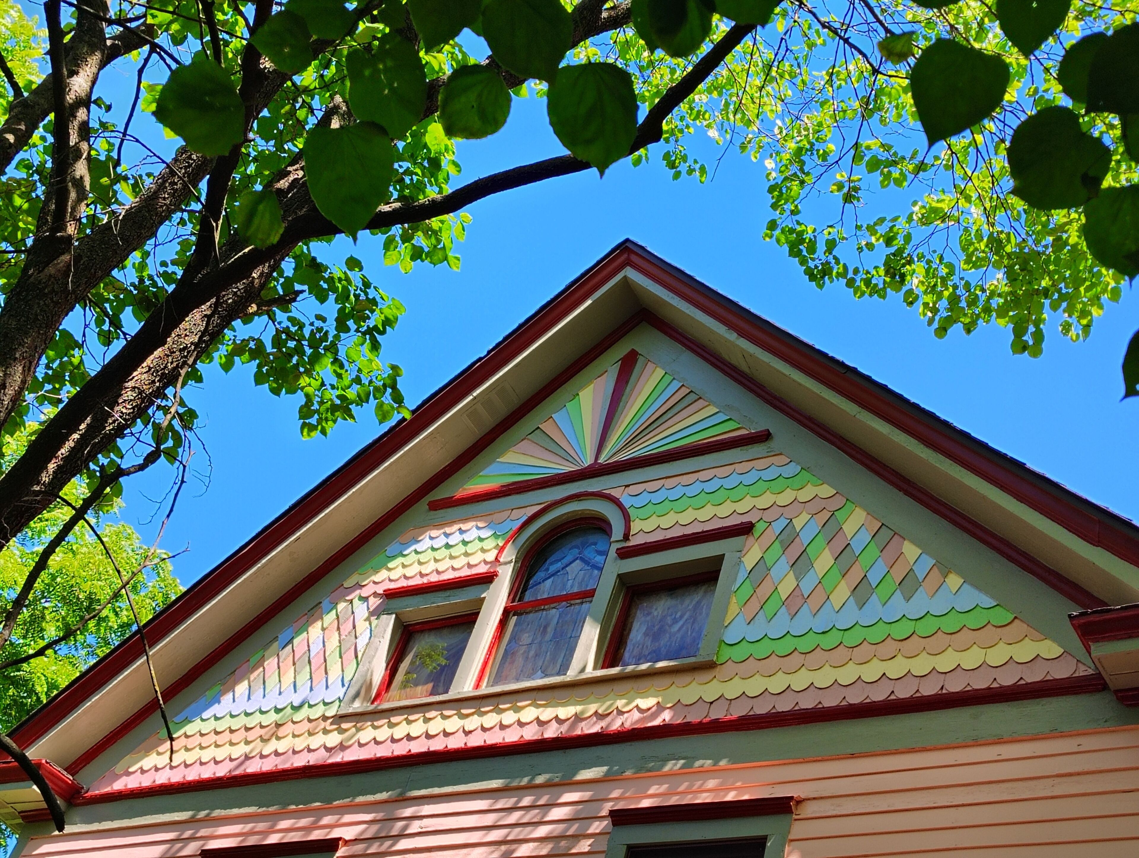 A building with a colorful roof and a window with a blue frame.
