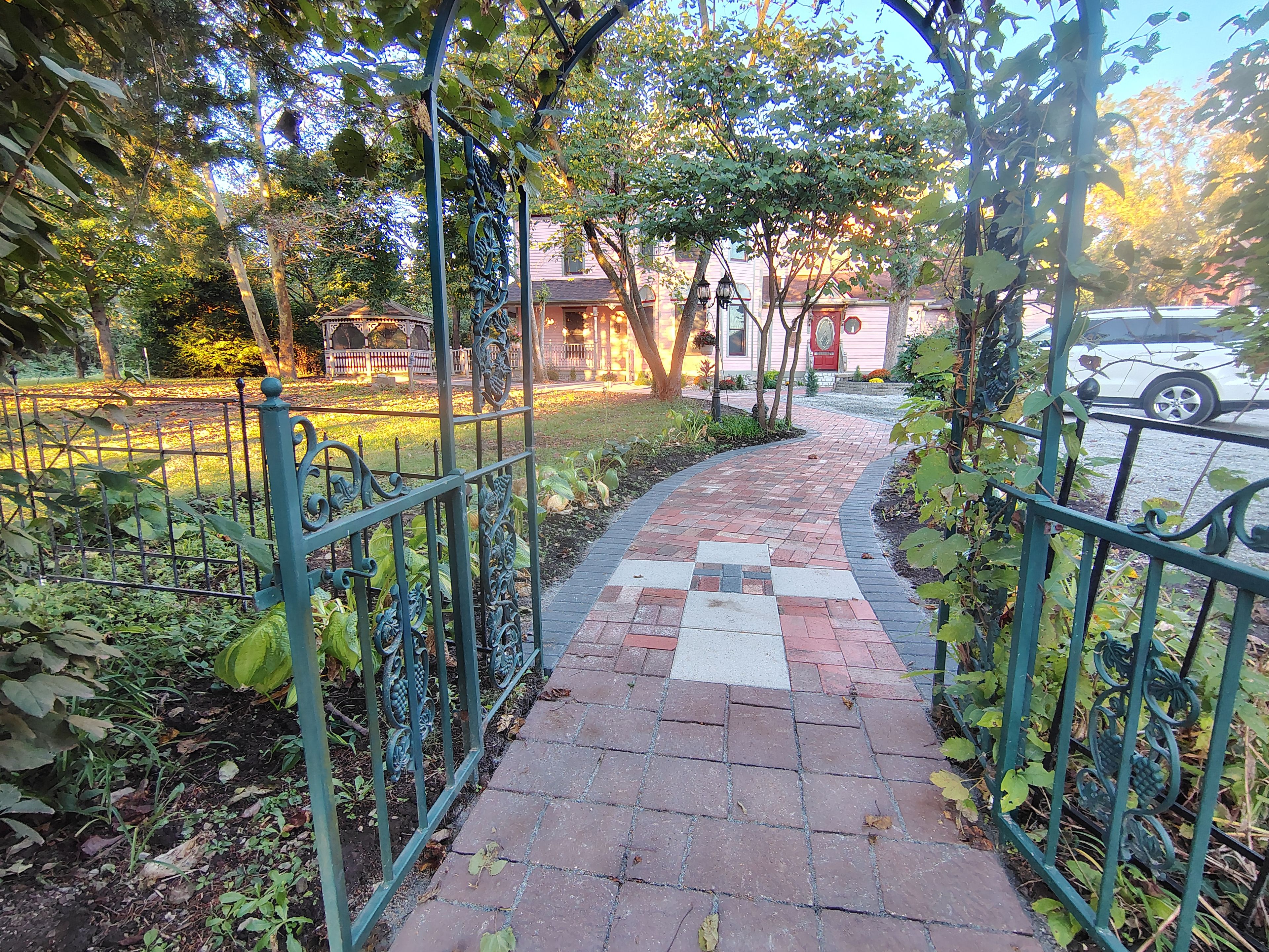Um caminho de tijolos que leva a um edifício com área de jardim.