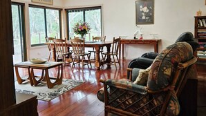 Un soggiorno con zona pranzo, arredi in legno e ampie finestre.