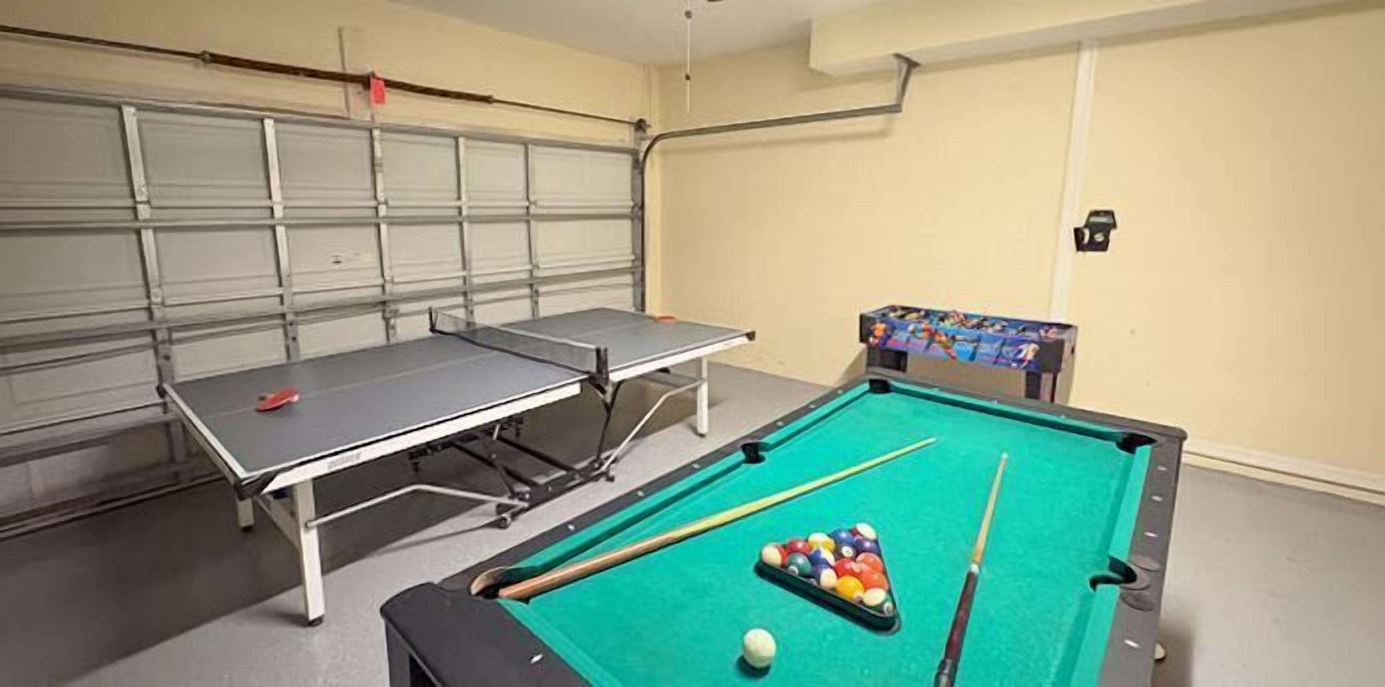 Ein Billardtisch mit Kugeln und Spielstangen sowie ein Billardständer.