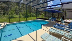 Piscina ao ar livre coberta com espreguiçadeiras e guarda-sóis.