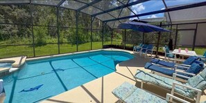 A covered outdoor swimming pool with lounge chairs and umbrellas. - 648 - Spacious 6-Bedroom Emerald Island Retreat with Pool, Spa & Games Room Near Disney (Kissimmee)