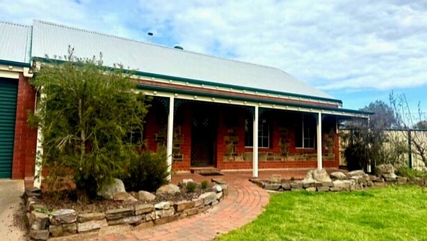 A two-story building with a covered porch and a brick facade.