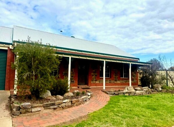 A two-story building with a covered porch and a brick facade.
