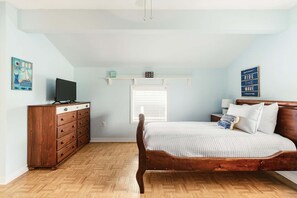 A bedroom with a wooden bed, a dresser, a television, and a window with blinds. - Heated Pool Home with Foosball/BBQ/Kids Playroom (Englewood)