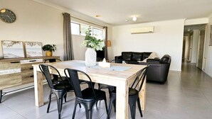 Ein zeitgemäßer Wohnraum mit Essbereich, einer Couch und einer Uhr an der Wand.