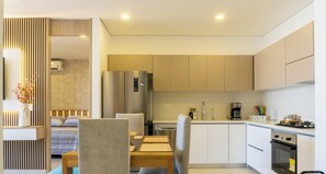 Eine moderne Küche mit Essbereich, Edelstahlgeräten und einem klaren, minimalistischen Design.