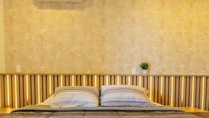 A bed with a wooden headboard and a potted plant on the wall.