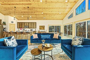 Bright, spacious, and filled with warmth. this stunning open-concept living area invites relaxation with its cozy seating, modern kitchen, and beautiful woodland views through floor-to-ceiling - Modern and Luxury • Mini Golf • Hot Tub • Hot Tub (Broken Bow)