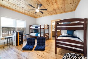 Une chambre avec des lits superposés, un bureau et une chaise.