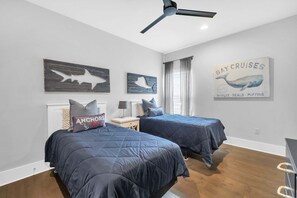A bedroom with two beds, a ceiling fan, and nautical-themed wall art. - 🦩Book Me Baby! High Tide in Miramar Beach ~ Golf Cart Included🦩 (Miramar Beach)
