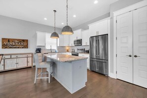 A modern kitchen with white cabinetry, a central island, stainless steel appliances, and pendant lighting. - 🦩Book Me Baby! High Tide in Miramar Beach ~ Golf Cart Included🦩 (Miramar Beach)