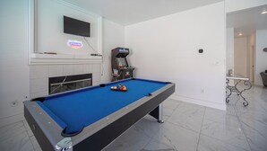 A pool table with a neon sign, a television mounted above it, and a ceiling fan. - Gorgeous 5-bedroom house with Pool in North Las Vegas (North Las Vegas)