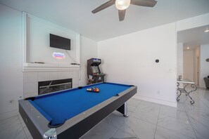 A pool table with a neon sign, a television mounted above it, and a ceiling fan. - Gorgeous 5-bedroom house with Pool in North Las Vegas (North Las Vegas)