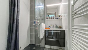 A modern bathroom with a glass shower enclosure, a white sink, and a mirror above the countertop. - Awesome apartment in Antibes Les Pins with house sea view (Antibes Les Pins)