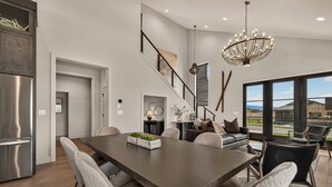 A modern kitchen with a large island, stainless steel appliances, and a view to the outdoors. - Teton Sunset 3BR luxury home sleeps 12 with private hot tub & unbeatable Teton mtn views. (Driggs)