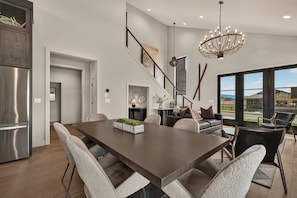 A modern kitchen with a large island, stainless steel appliances, and a view to the outdoors. - Teton Sunset 3BR luxury home sleeps 12 with private hot tub & unbeatable Teton mtn views. (Driggs)