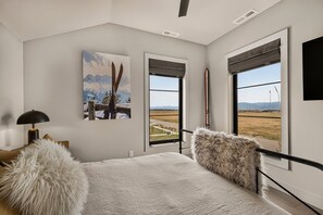 A bedroom with a large bed, a painting, and a ski pole. - Teton Sunset 3BR luxury home sleeps 12 with private hot tub & unbeatable Teton mtn views. (Driggs)