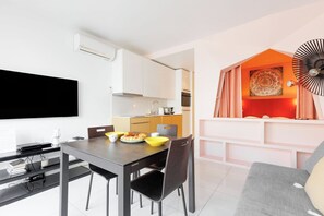 Eine moderne Wohnung mit Essbereich, Küche und einer gemütlichen Sitzecke mit Ventilator.