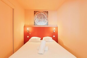 Ein Hotelzimmer mit einem Bett, zwei Wandleuchten und einem Zierteil an der Decke.