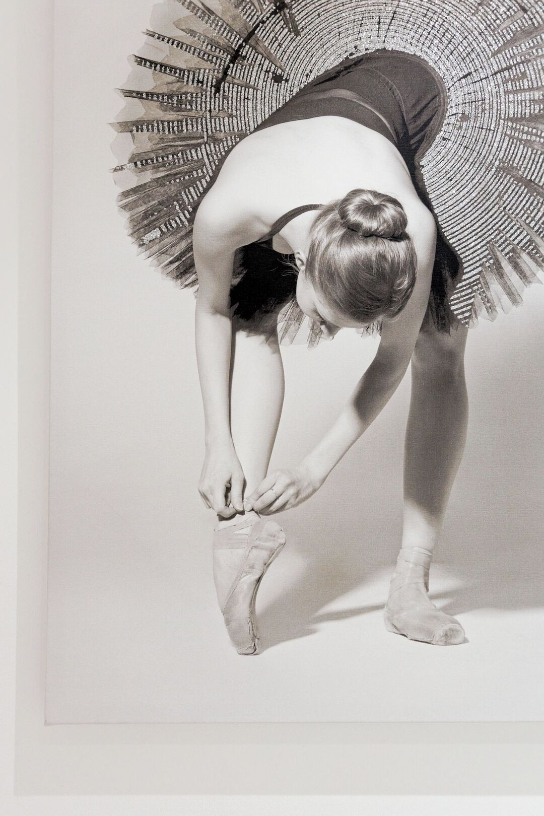 A person in a ballet pose, wearing a tutu and ballet shoes, with a patterned skirt.