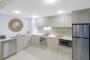 Eine moderne Küche mit Edelstahlgeräten, einem Backofen und einer Mikrowelle.