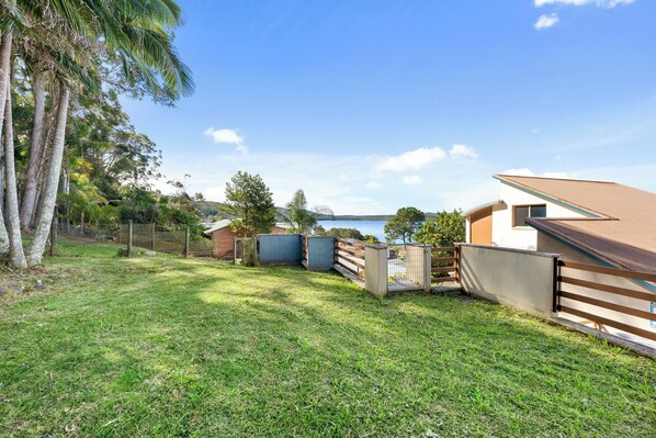 A residential property with a fenced yard, a pool, and a view of a lake.