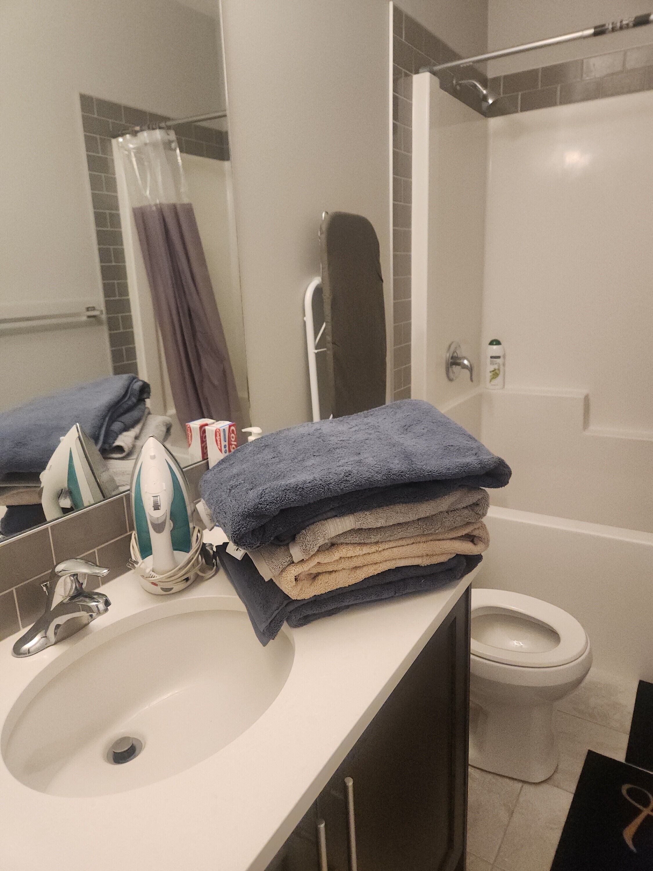 Une salle de bain équipée d’un lavabo, d’un miroir, d’un porte-serviettes et de toilettes.