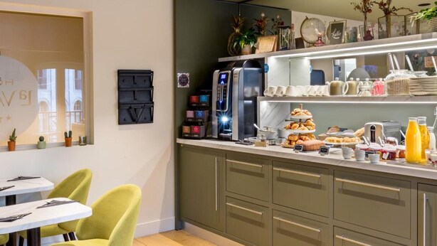 Uma cozinha moderna com máquina de café integrada, um balcão de café da manhã e diversas opções para o café da manhã.