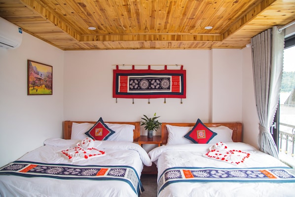 Habitación de hotel con dos camas, techo de madera, un cuadro en la pared y una ventana con cortinas.
