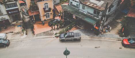 Vista de la calle con edificios, un coche aparcado y un paso de peatones.