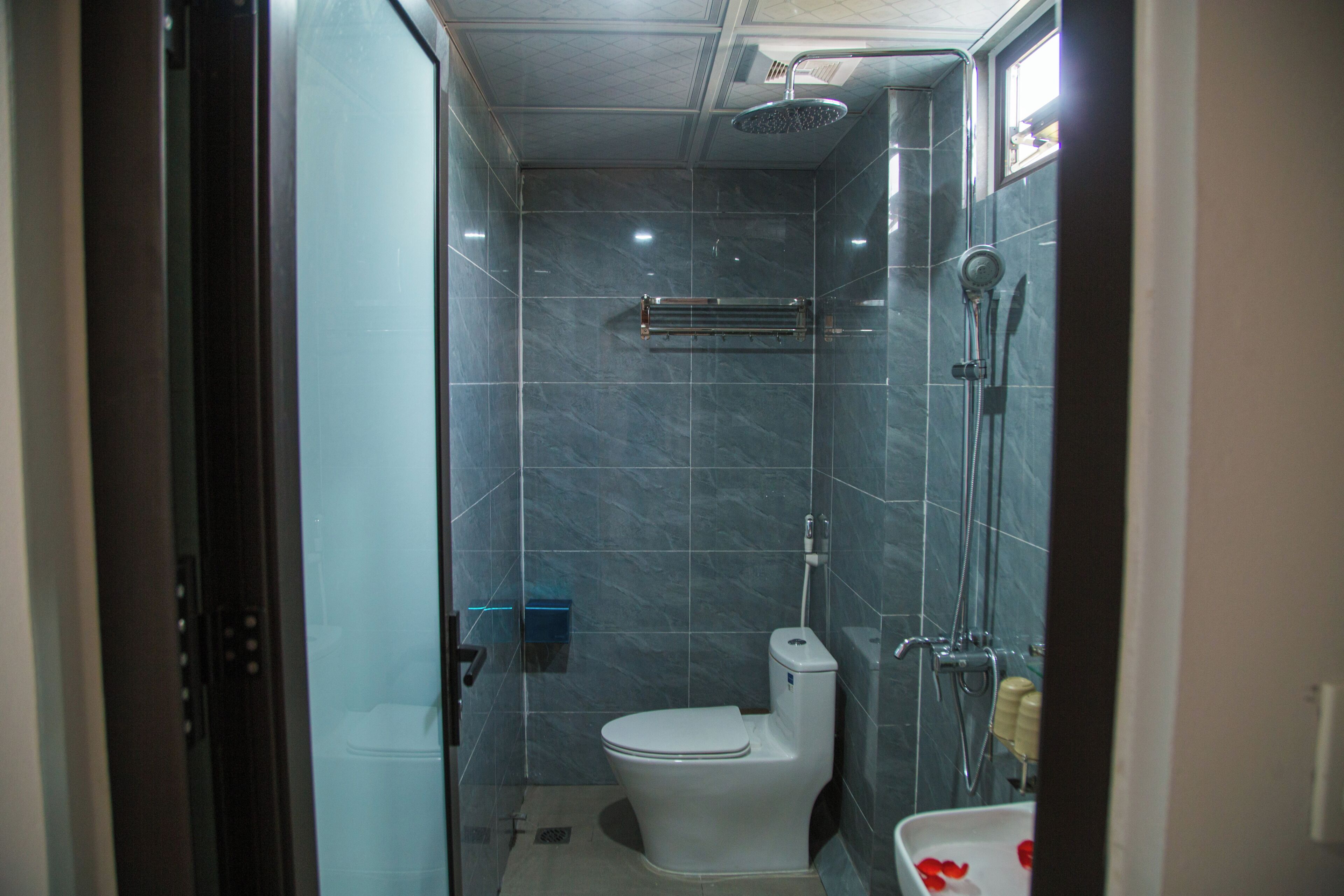 A compact bathroom with a toilet, a shower, and a sink.
