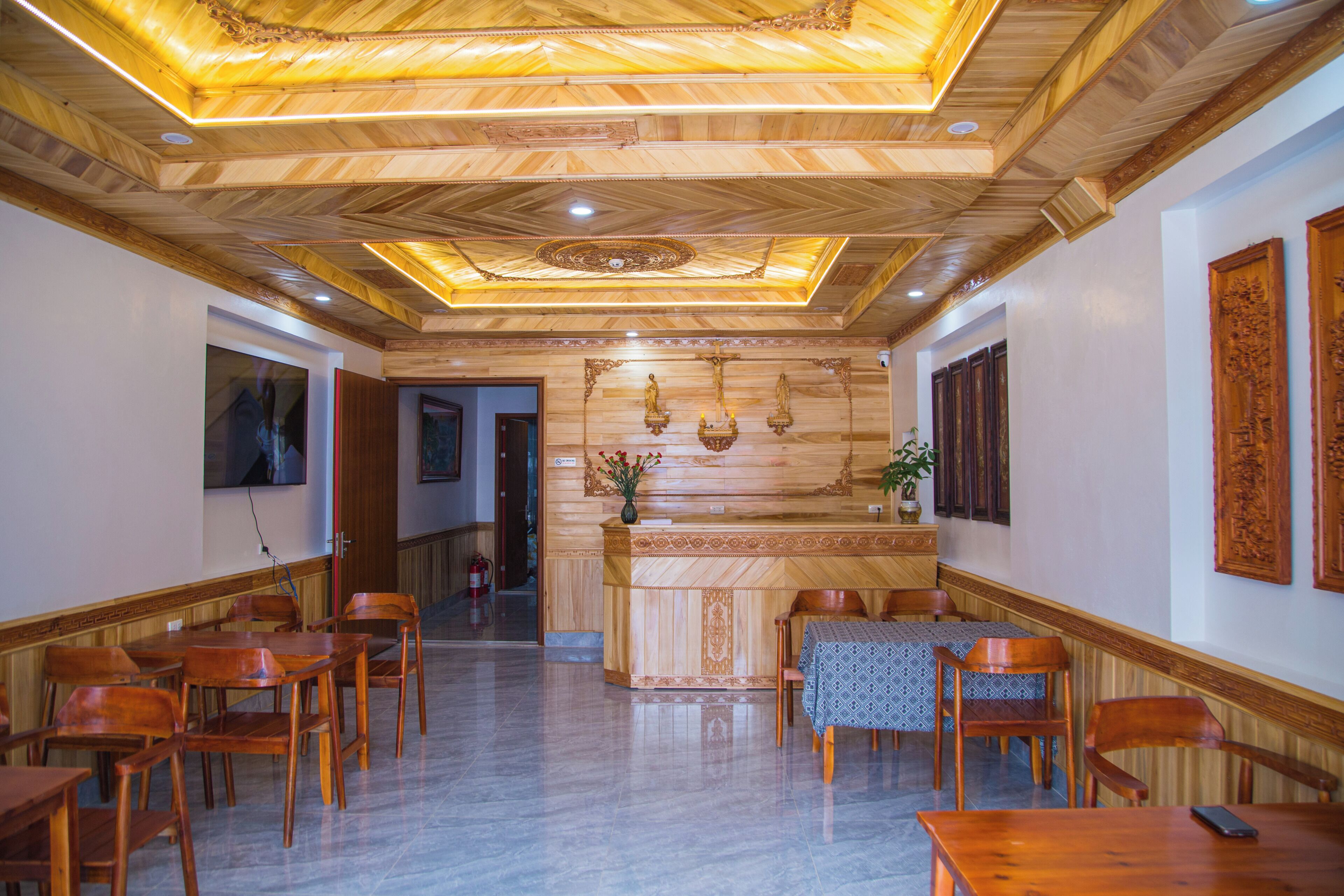 A hotel lobby with wooden paneling, a reception desk, and seating arrangements.