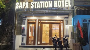 Un edifici de diverses plantes amb un rètol que diu 'SAPA STATION HOTEL'.