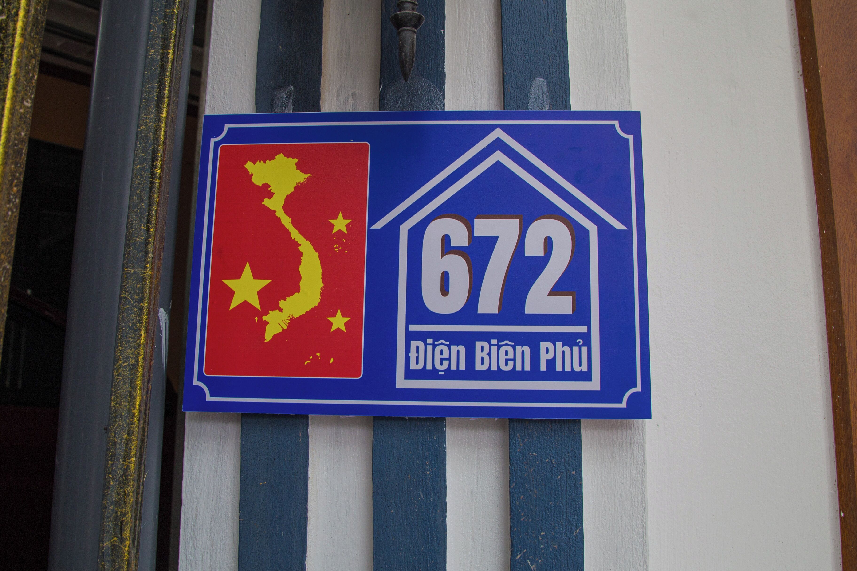 Un letrero con un mapa rojo y amarillo, el número 672, y texto en vietnamita.