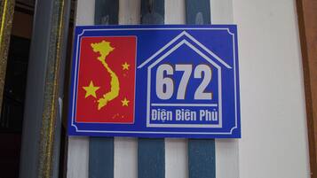 Un panneau avec une carte aux couleurs rouge et jaune, le numéro 672 et du texte en vietnamien.