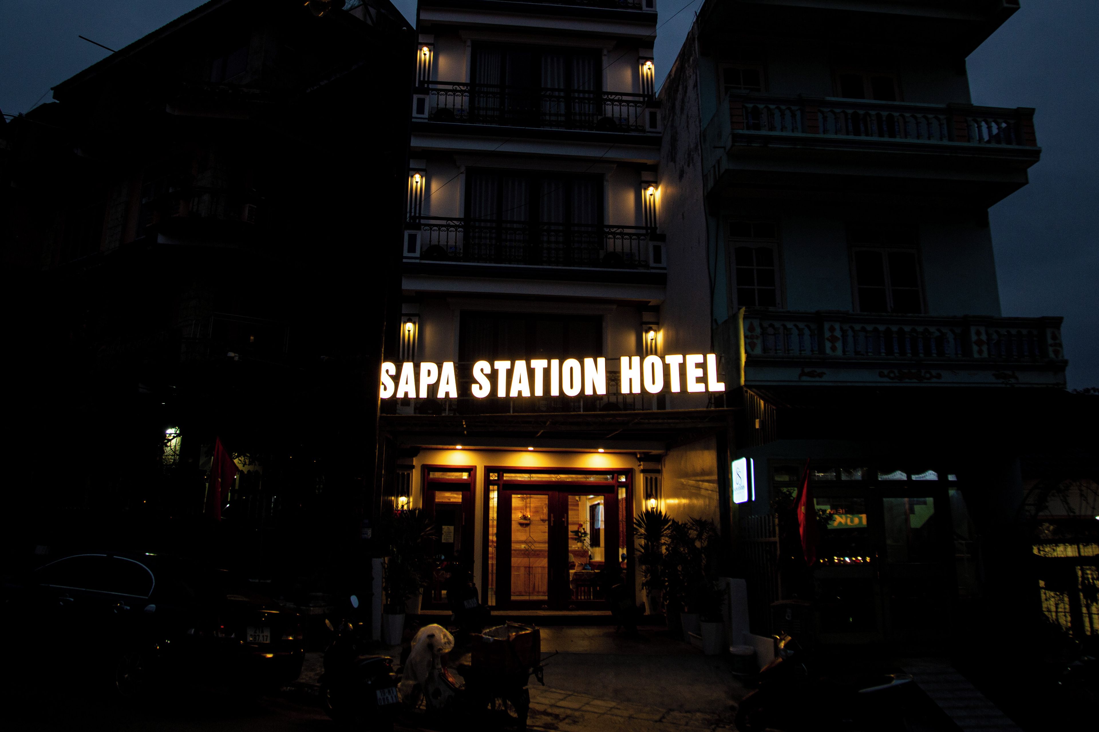 The exterior of Sapa Station Hotel with a prominent illuminated sign.