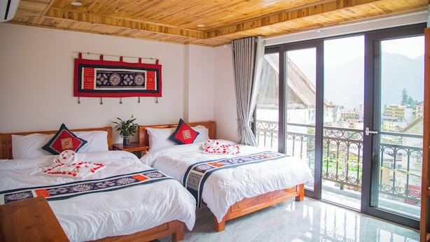 A hotel room with two beds, a wooden ceiling, a large window with a view, and a wall hanging.