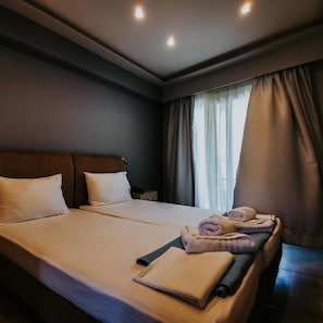A hotel room with a large bed, a bedside table, and a window with curtains. - Three Island View Hotel (Lefkada)