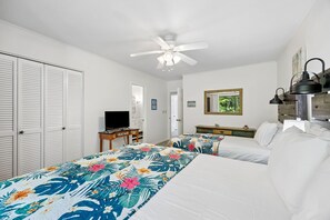 A bedroom with two beds, a ceiling fan, a TV, and a dresser. - Updated 2BR - Omni villa - Near beach (Fernandina Beach)