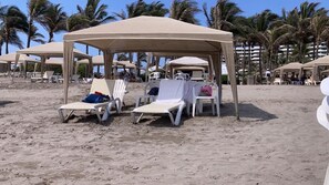 A beach with sun umbrellas and lounge chairs.