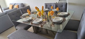 A dining table set with plates, glasses, and decorative flowers.
