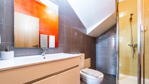 A modern bathroom with a shower, toilet, and vanity. - Casas Da Alegria (Coimbra)