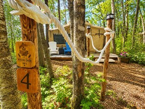 Une zone boisée où se trouve un panneau en bois indiquant « Camping Wishing Creek, emplacement n° 4 ».