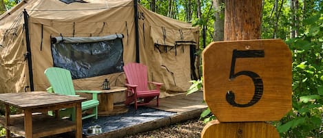 A tent labeled 'Wishing Creek Tent 5' with a wooden post and a rope.