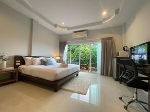 A modern bedroom with a bed, a desk, and a television. - The Zen Suites (Rawai)