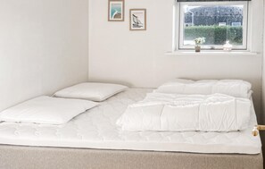 A bed with white bedding and a window with a view of greenery. - Nice home in Assens with WiFi (Assens)