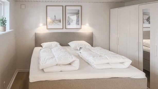 A bed with a headboard, two bedside tables, and a wardrobe with a mirror. - Nice home in Assens with WiFi (Assens)