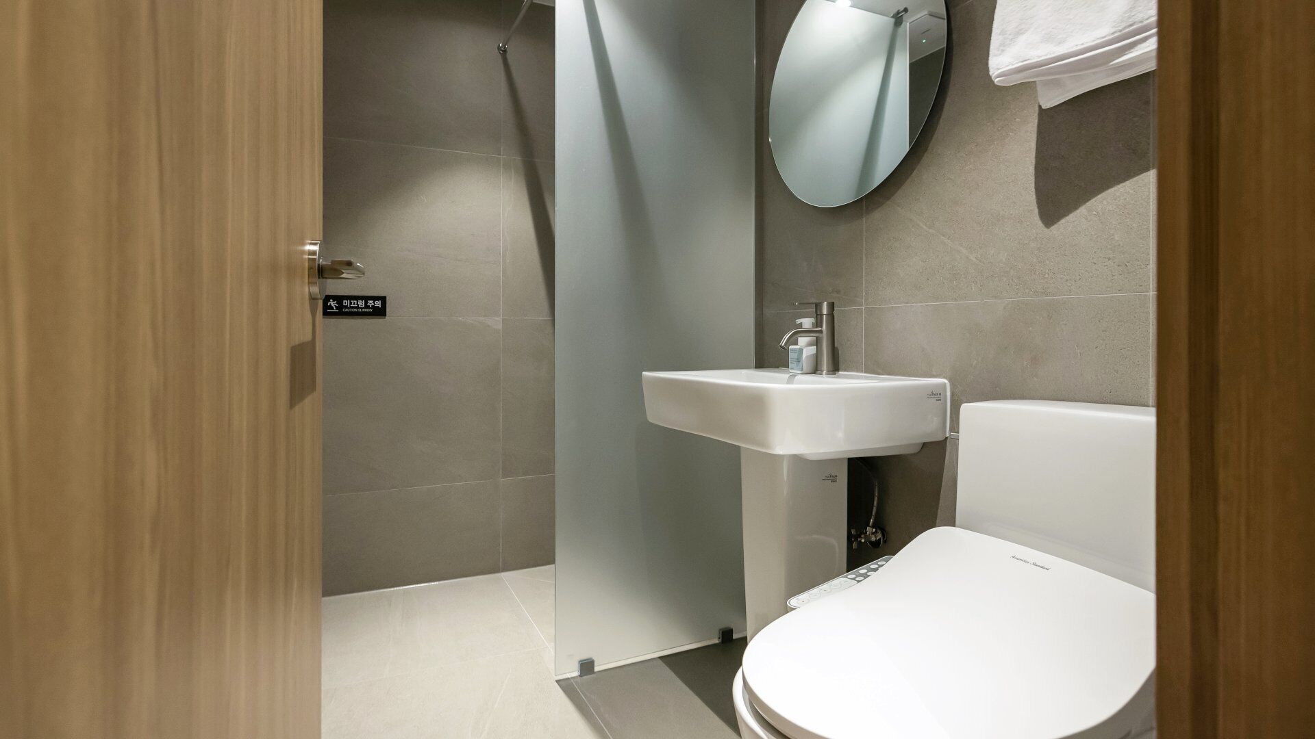 A modern bathroom with a toilet, sink, and shower.